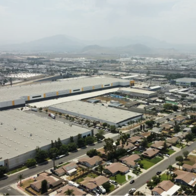 Smog and large warehouses next to homes in Bloomington, California.